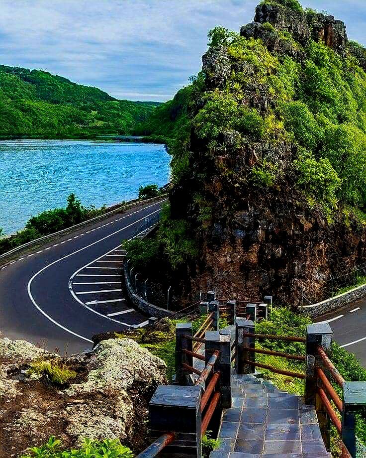 Malowniczy widok na krętą drogę otoczoną bujną roślinnością i wodami w Mauritiusie.